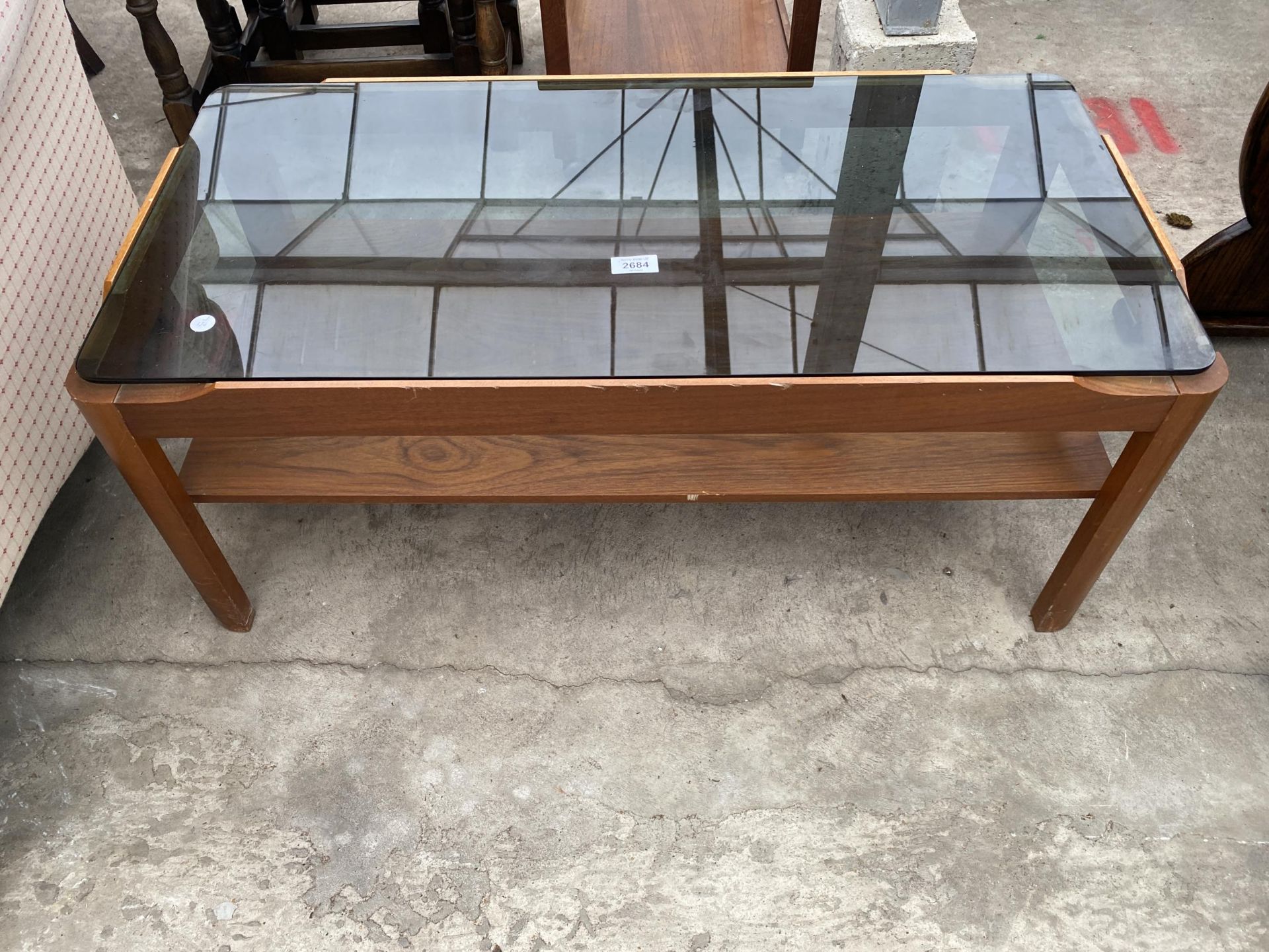 A RETRO TEAK TWO TIER COFFEE TABLE WITH INSET SMOKED GLASS TOP, 34 X 17"