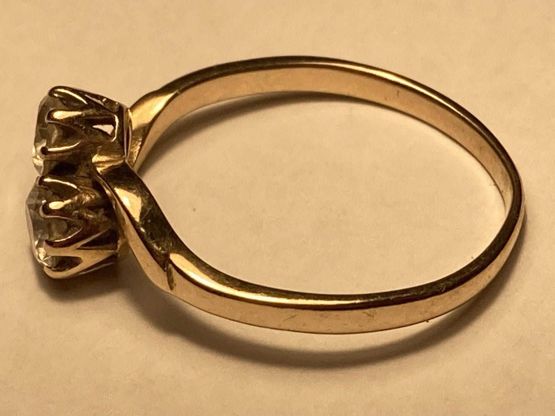 A 9 CARAT GOLD RING WITH TWO CUBIC ZIRCONIAS ON A TWIST DESIGN SIZE J - Image 2 of 3