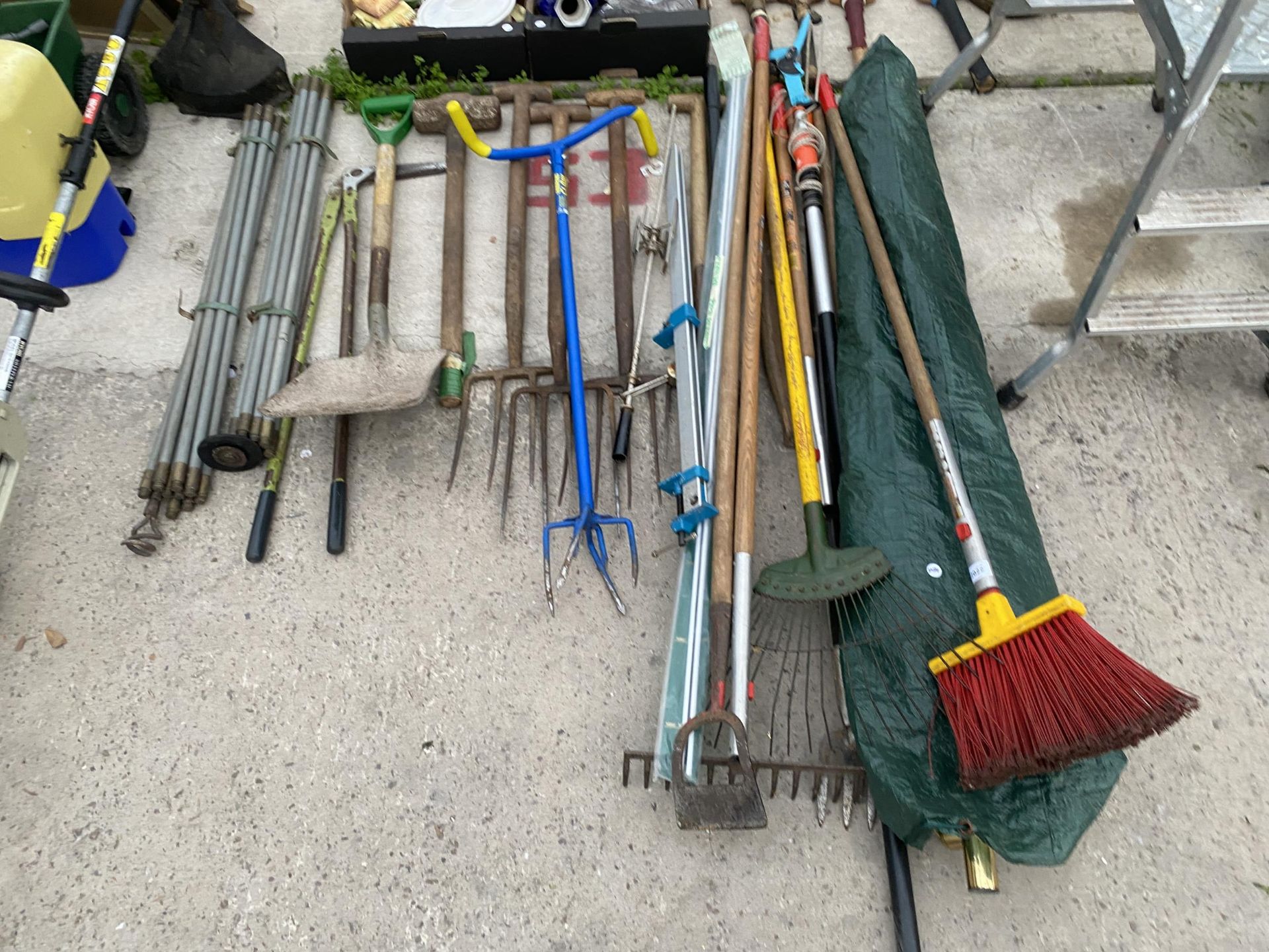 A LARGE ASSORTMENT OF GARDEN TOOLS TO INCLUDE FORKS, RAKES AND DRAINING RODS ETC