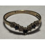 A 9 CARAT GOLD WISHBONE RING WITH THREE SAPPHIRES AND FOUR CUBIC ZIRCONIAS SIZE M/N