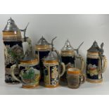 A COLLECTION OF SEVEN VINTAGE GERMAN BEER STEINS, LARGEST 28 CM