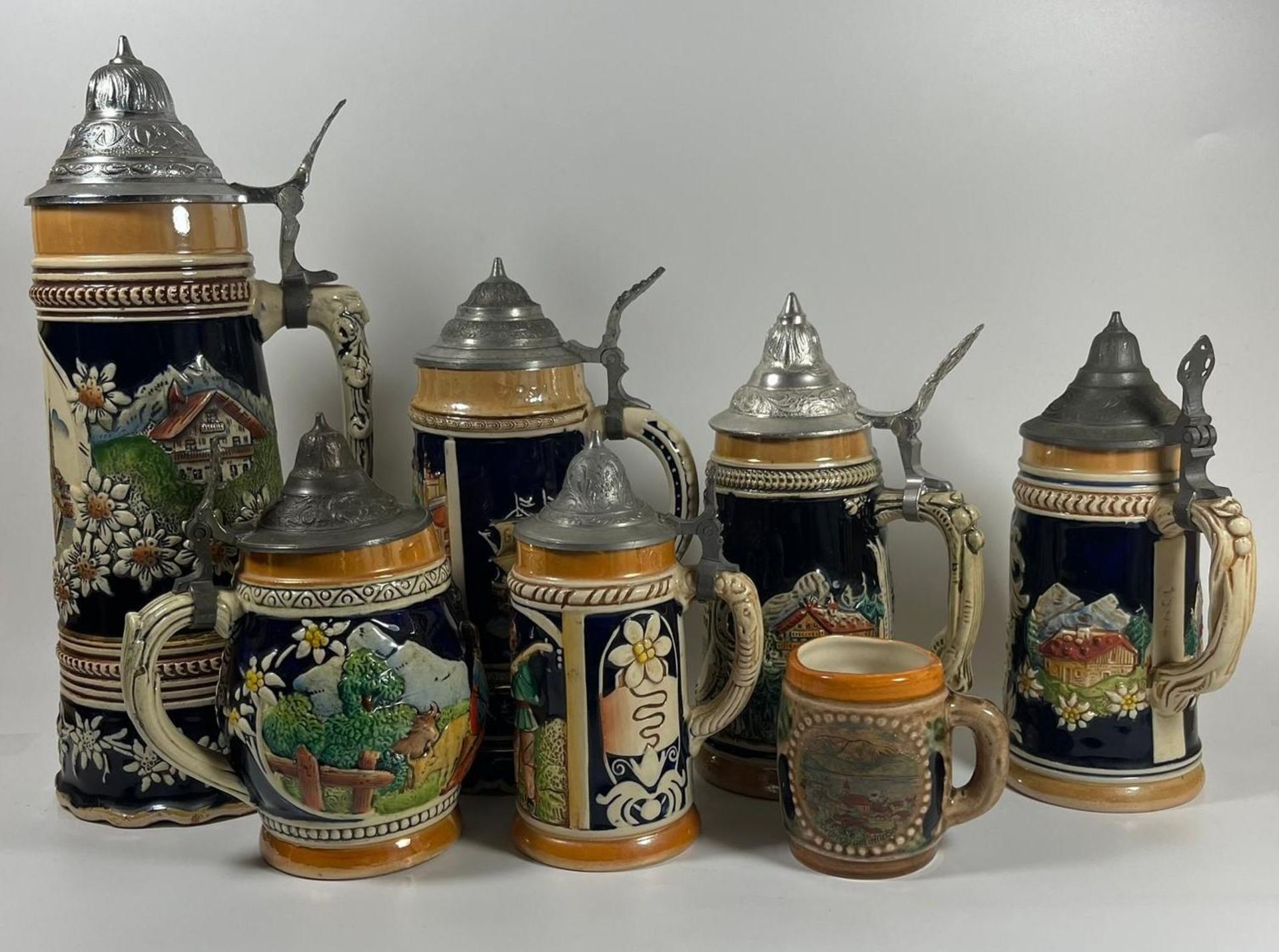 A COLLECTION OF SEVEN VINTAGE GERMAN BEER STEINS, LARGEST 28 CM