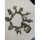 A SILVER CHARM BRACELET WITH EIGHT CHARMS AND A HEART PADLOCK