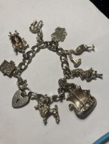 A SILVER CHARM BRACELET WITH EIGHT CHARMS AND A HEART PADLOCK