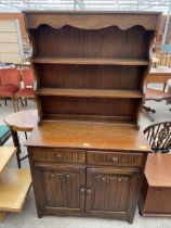 A REPRODUCTION OAK DRESSER COMPLETE WITH RACK AND LINENFOLD DOORS TO THE BASE, 37.5" WIDE