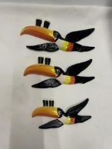A SET OF THREE GRADUATED CARLTON WARE GUINNESS TOUCANS IN FLIGHT WALL HANGING DECORATIONS