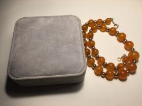 A MARKED 9 CARAT GOLD AND MILK AMBER GOLD NECKLACE WITH A PRESENTATION BOX