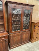 A 19TH CENTURY MAHOGANY TWO DOOR BOOKCASE ON BASE, 56" WIDE, WITH CUPBOARDS TO THE BASE