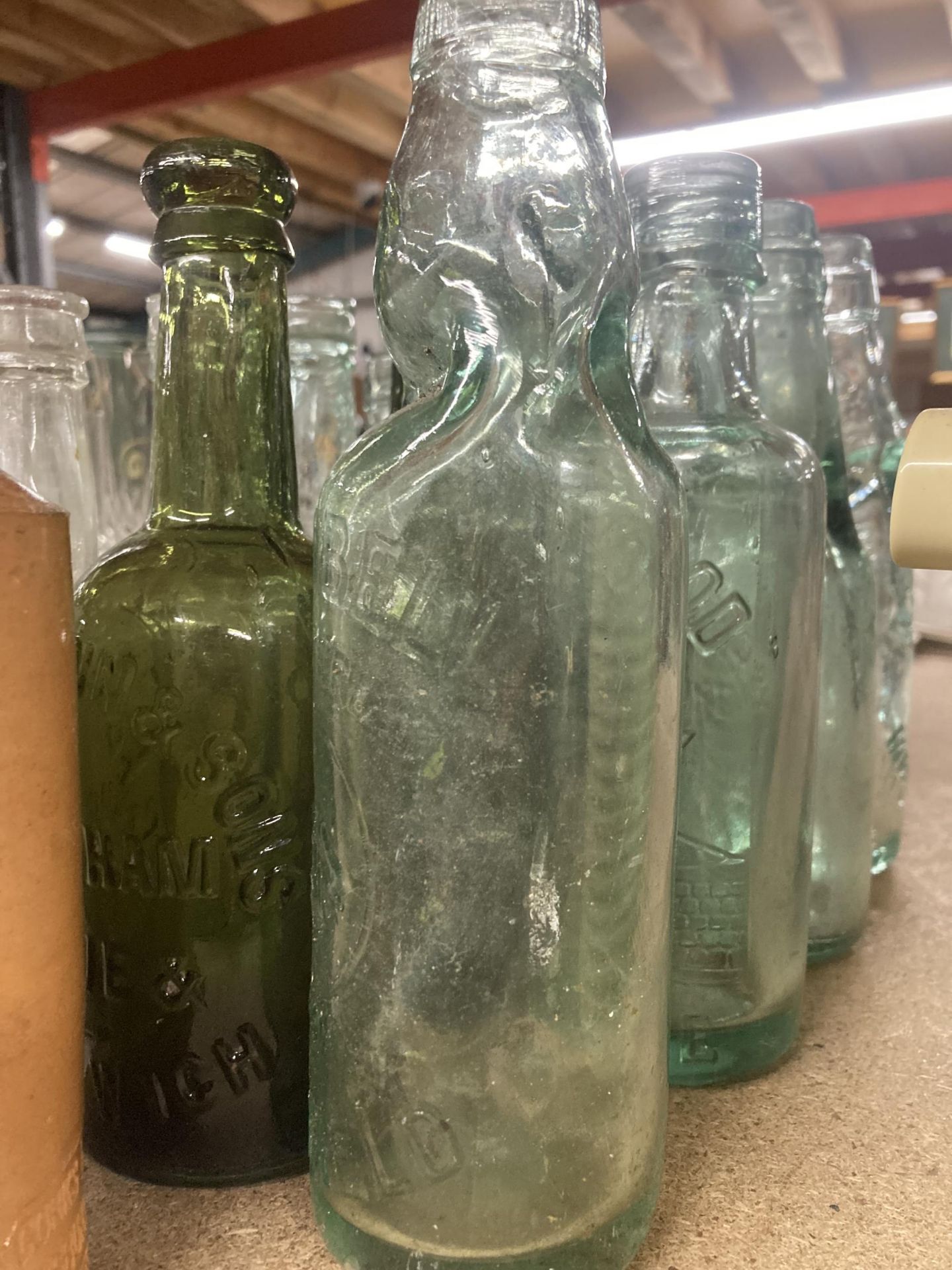 A COLLECTION OF VINTAGE GLASS BOTTLES WITH ADVERTISING ON THEM PLUS TWO STONE ONES - Image 4 of 4