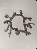 A SILVER CHARM BRACELET WITH NINE CHARMS AND A HEART PADLOCK