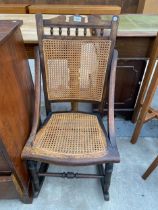 A LATE VICTORIAN BEECH FRAMED ROCKING CHAIR WITH SPLIT CANE SEAT AND BACK