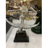 A VINTAGE WHITE METAL MODEL OF A SWIFT CAR MASCOT ON A BASE, HEIGHT 14CM