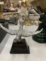 A VINTAGE WHITE METAL MODEL OF A SWIFT CAR MASCOT ON A BASE, HEIGHT 14CM