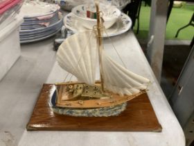 A MODEL OF A VINTAGE ITALIAN YACHT, ON A WOODEN PLINTH, WITH ENAMEL AND BRASS HULL, HEIGHT APPROX