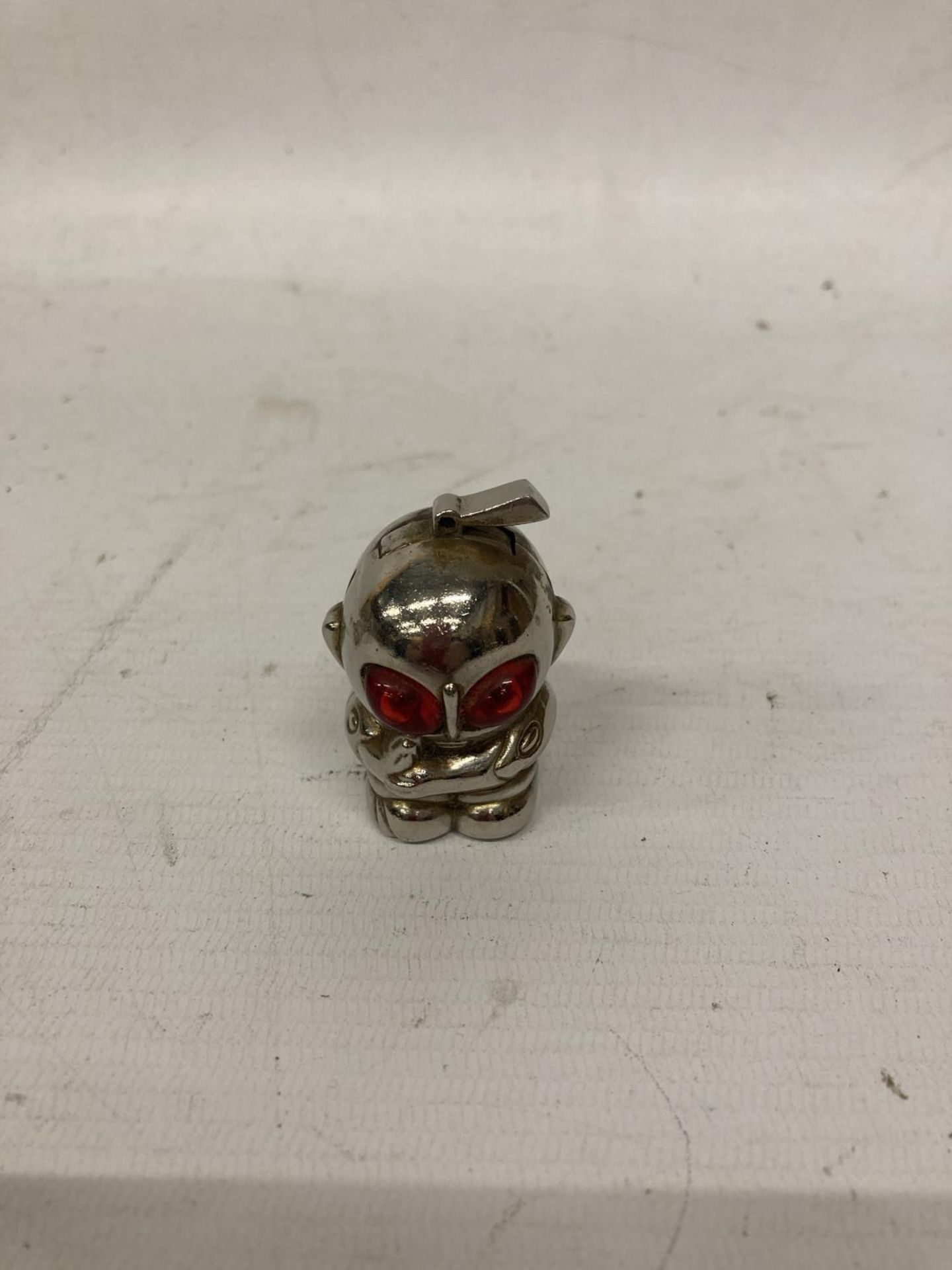 A VINTAGE WHITE METAL LIGHTER IN THE SHAPE OF AN ALIEN WITH RED EYES, HEIGHT 5CM - Bild 3 aus 3