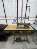 A BROTHER INDUSTRIAL SEWING MACHINE WITH TREADLE BASE AND ANGLE POISE LAMP