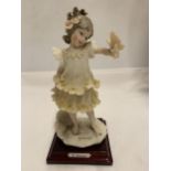 A 1986 FLORENCE FIGURE OF A GIRL HOLDING A BUTTERFLY, SIGNED G.ARMANI