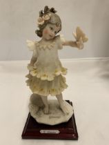 A 1986 FLORENCE FIGURE OF A GIRL HOLDING A BUTTERFLY, SIGNED G.ARMANI
