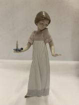 A NAO FIGURE OF A GIRL HOLDING A CANDLE