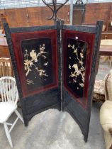 AN ORIENTAL EBONISED HARDWOOD TWO DIVISION SCREEN WITH APPLIED CHINOISERIE DECORATION