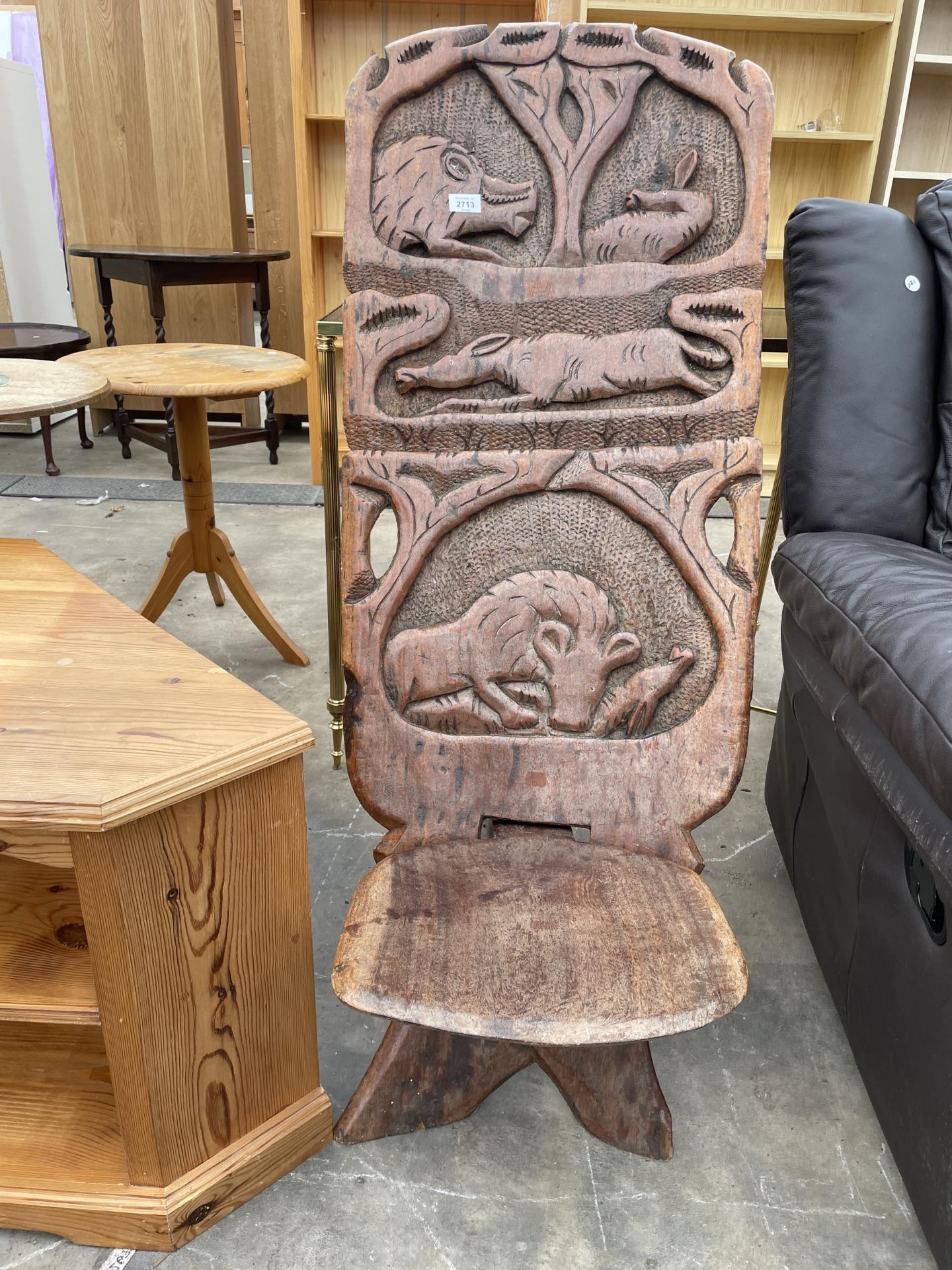 AN AFRICAN FOLDING TRIBAL CHAIR WITH WILD ANIMAL CARVINGS TO BACK