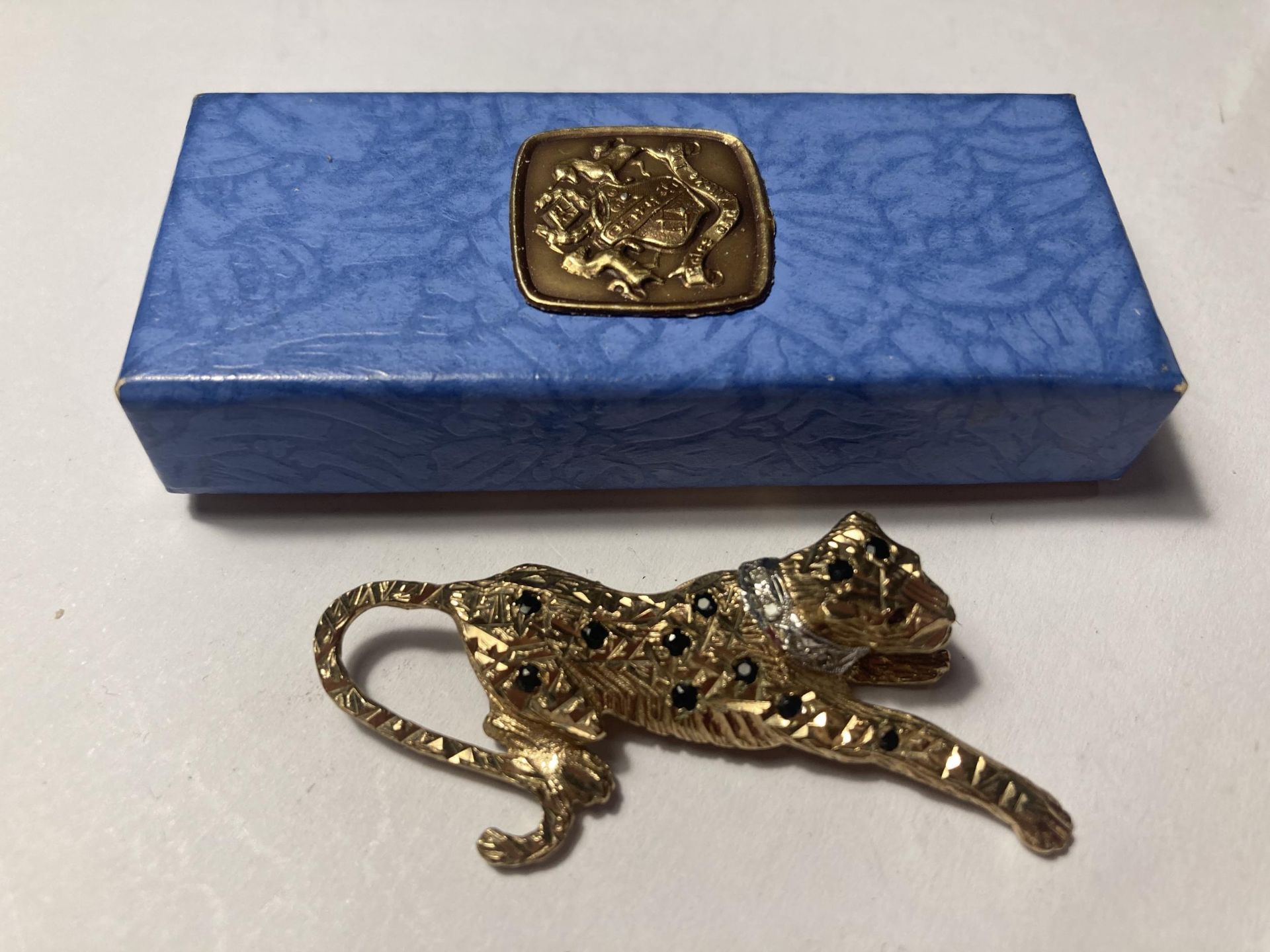 A MARKED 9 CARAT GOLD CARTIER STYLE LEOPARD BROOCH WITH SAPPHIRES, A DIAMOND COLLAR AND RUBY EYES IN