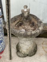 A SMALL CONCRETE BIRDBATH WITH BIRD FIGURE