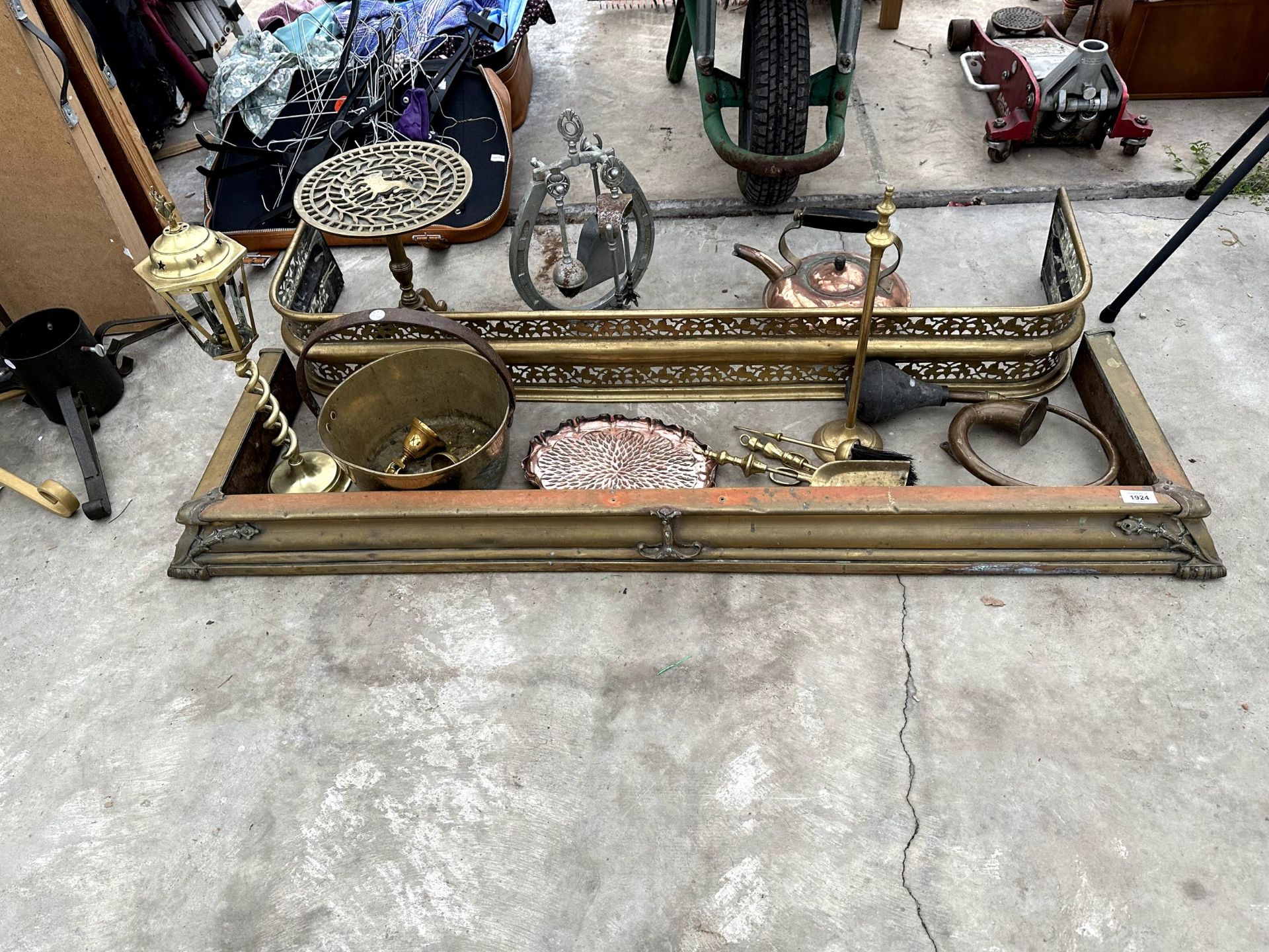 A LARGE QUANTITY OF BRASS AND COPPER ITEMS TO INCLUDE FIRE FENDERS, A DECORATIVE TRIVET STAND AND