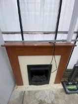 AN ELECTRIC FIRE WITH WOODEN SURROUND