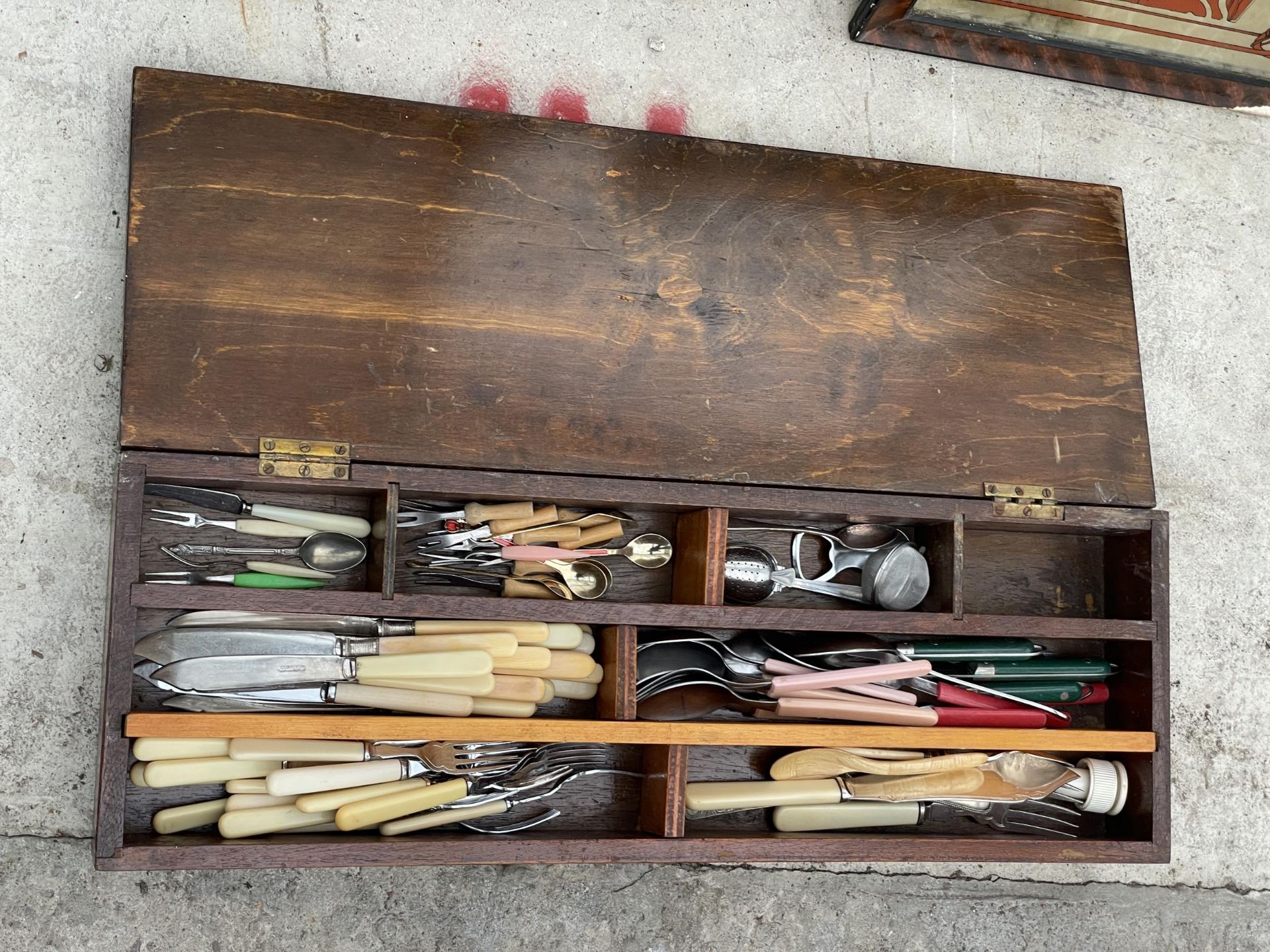 A VINTAGE WOODEN BOX WITH AN ASSORTMENT OF FLATWARE