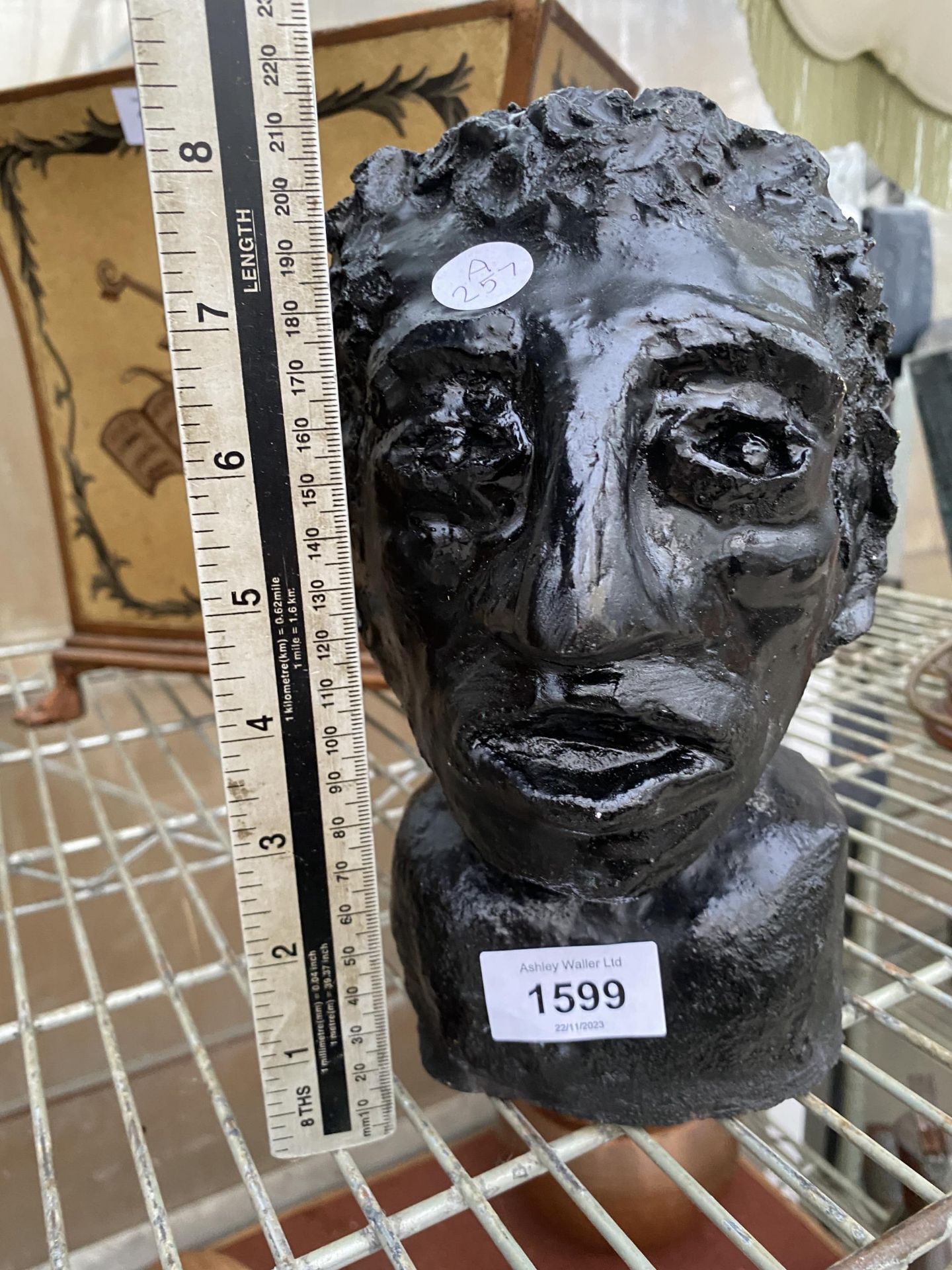 A PAINTED CONCRETE BUST OF A MALE