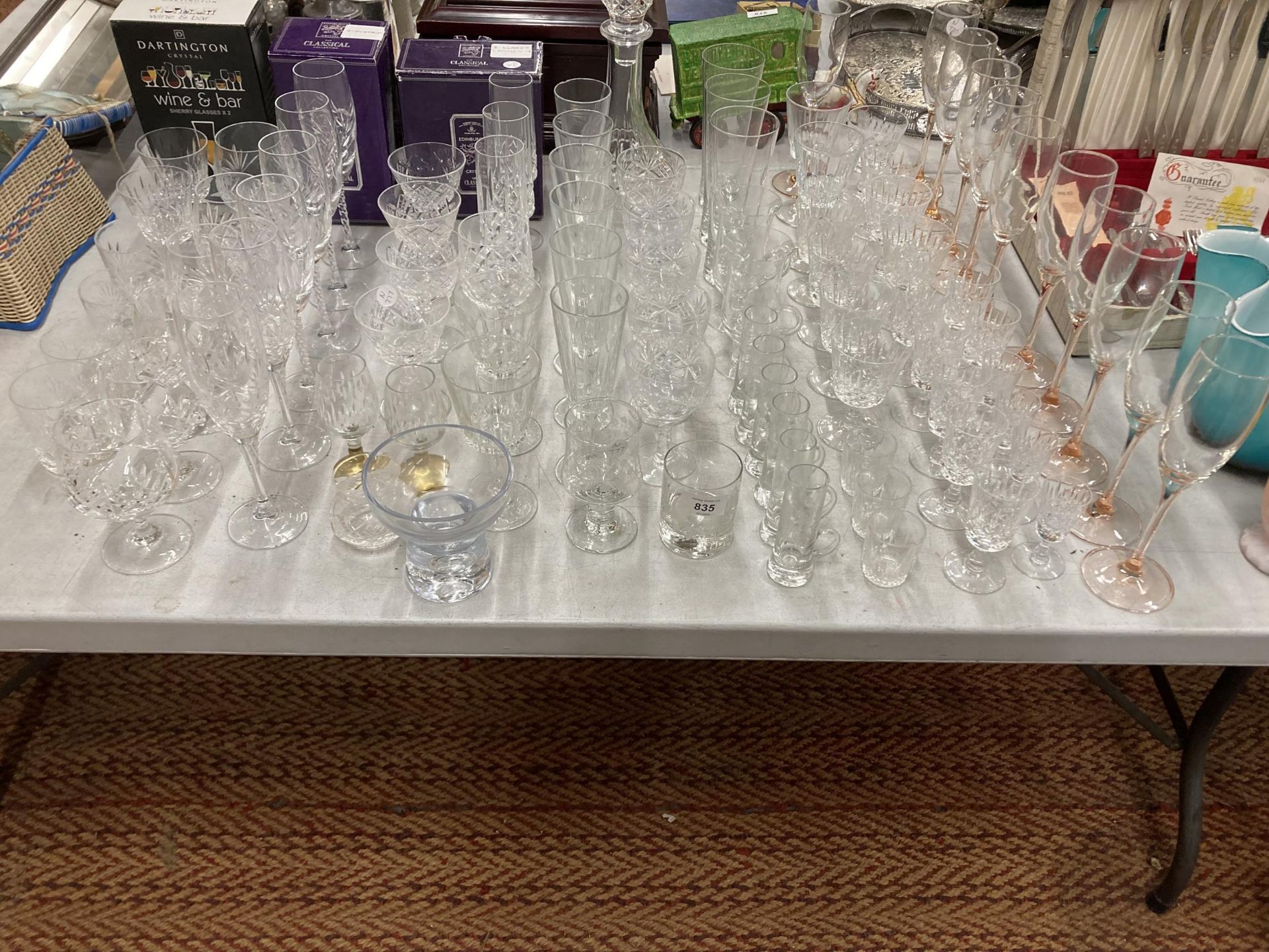 A VERY LARGE QUANTITY OF GLASSES, SOME CUT GLASS, TO INCLUDE CHAMPAGNE FLUTES, WINE, SHERRY, PORT,