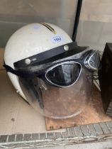 A MOTORBIKE HELMET AND A PAIR OF GOGGLES