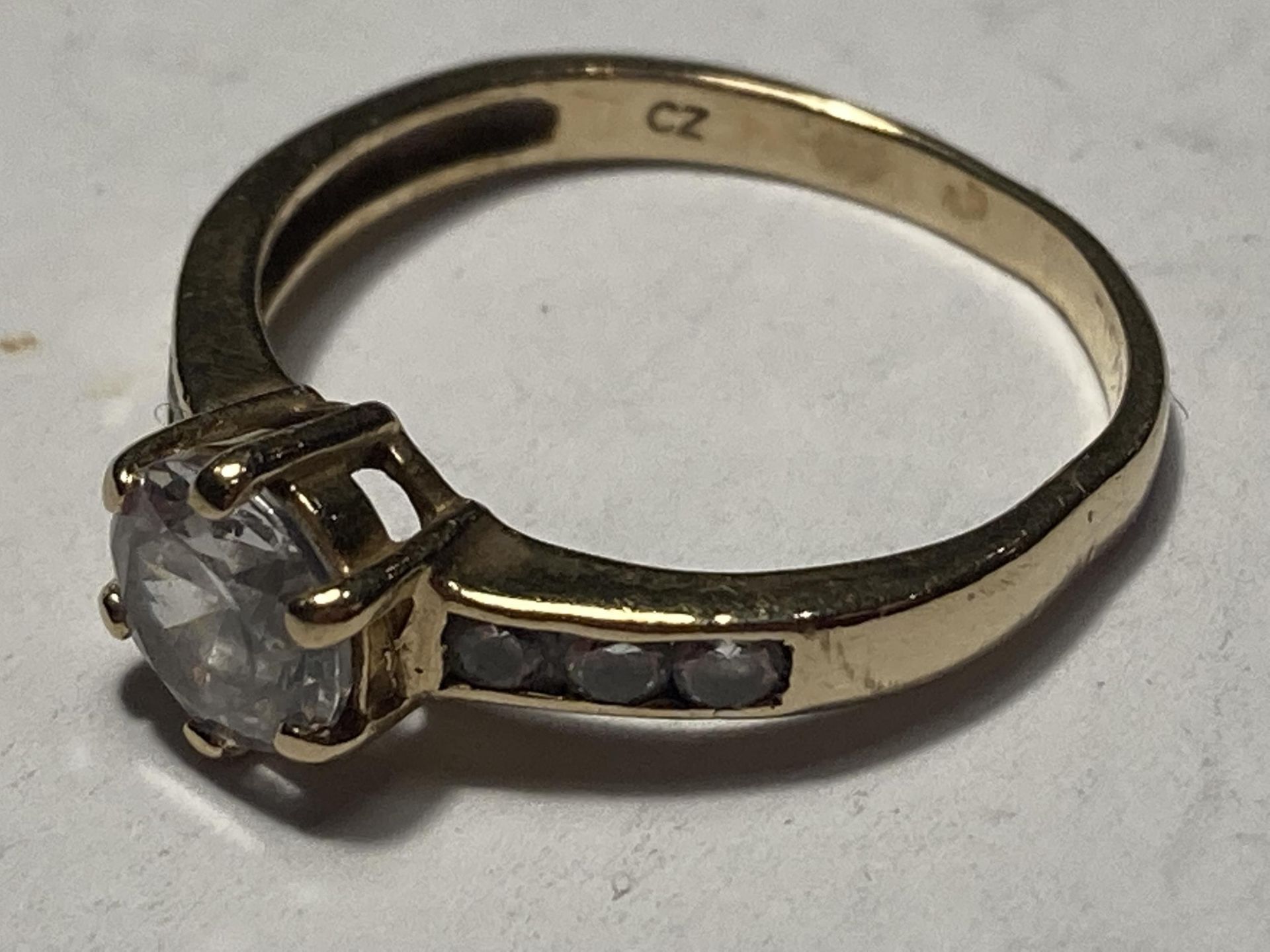 A 9 CARAT GOLD RING WITH A CENTRE CUBIC ZIRCONIA AND THREE TO EACH SHOULDER SIZE M - Bild 2 aus 3
