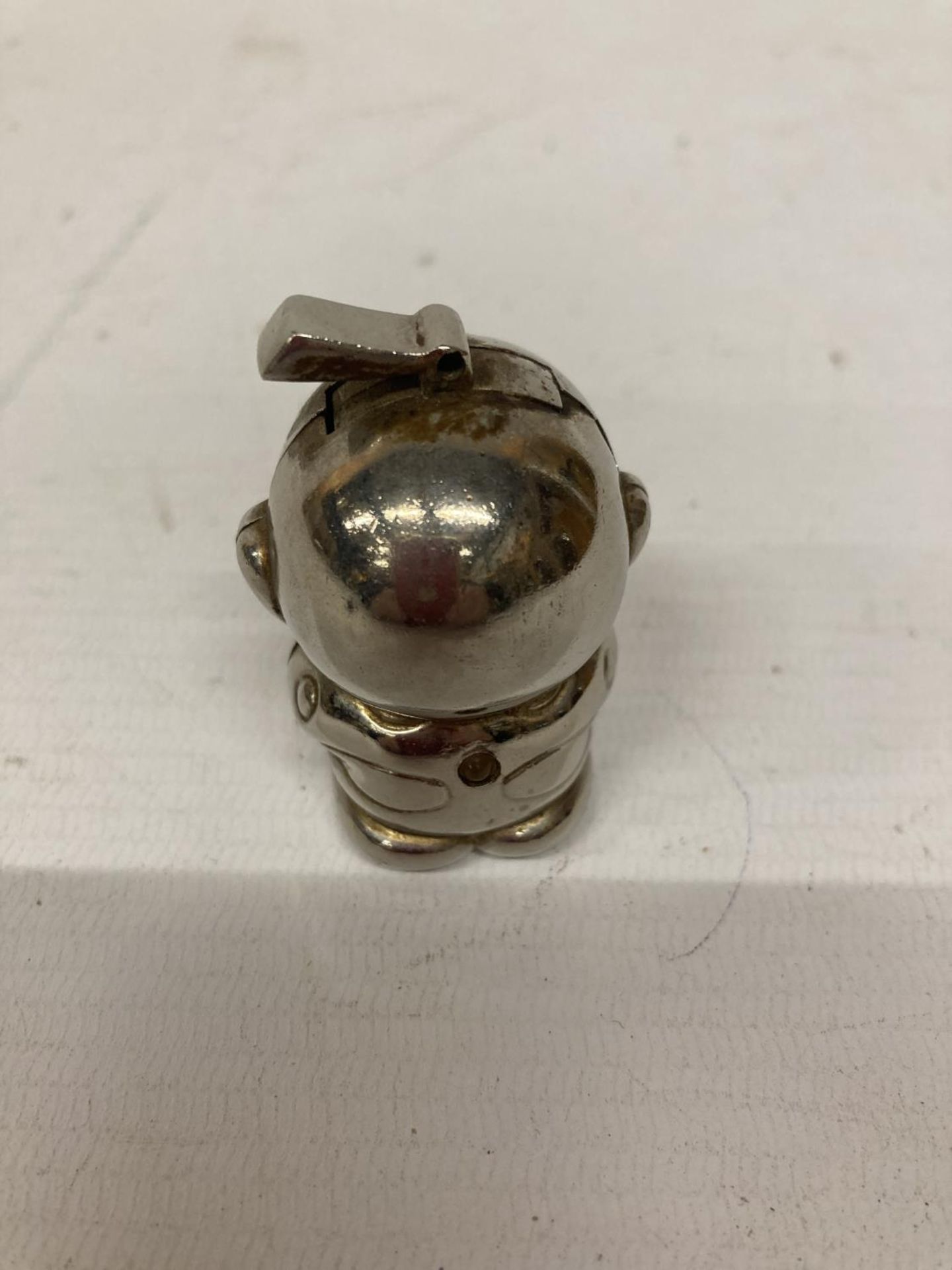 A VINTAGE WHITE METAL LIGHTER IN THE SHAPE OF AN ALIEN WITH RED EYES, HEIGHT 5CM - Bild 2 aus 3