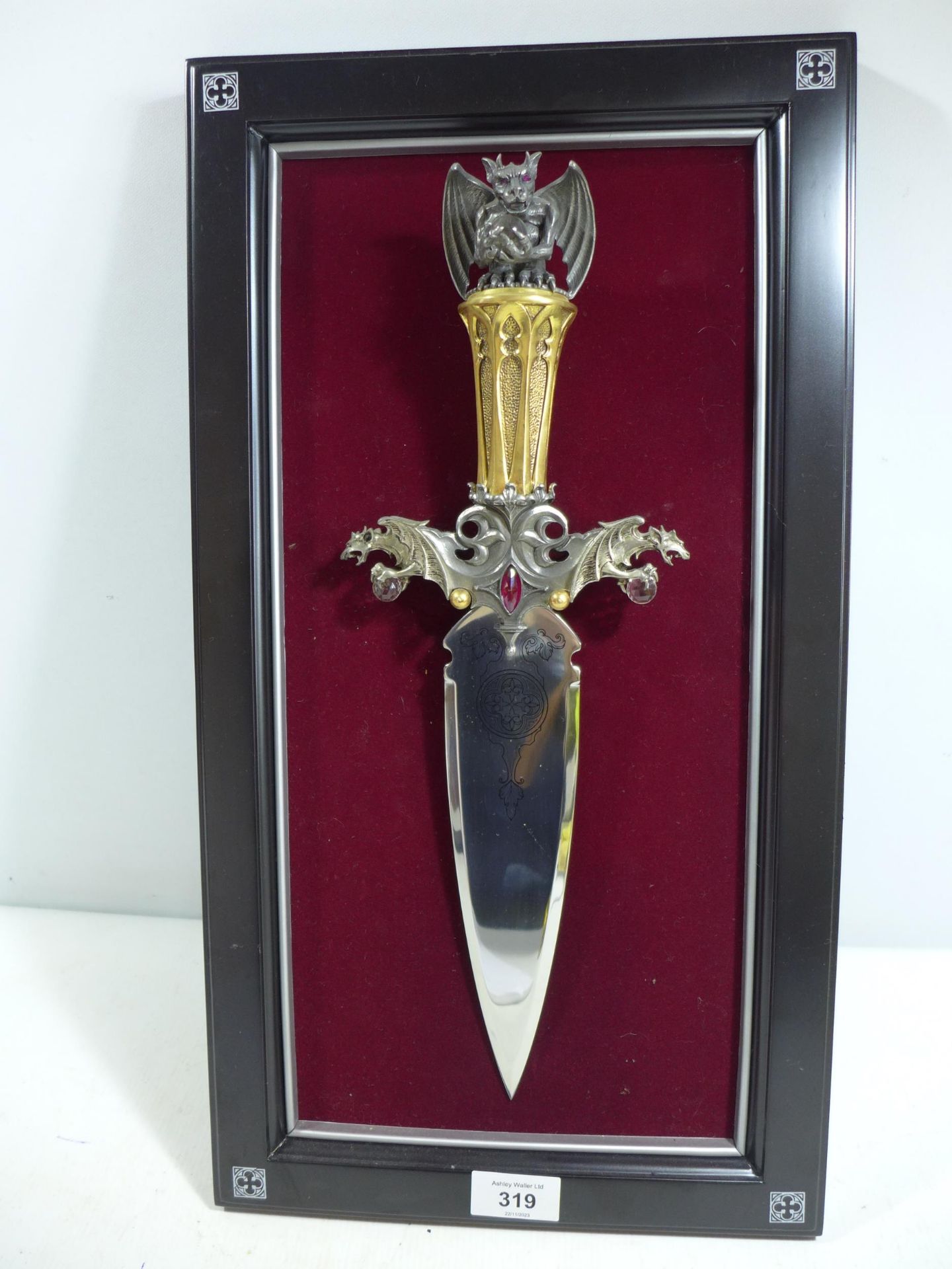 A FANTASY DAGGER MOUNTED ON A WOODEN FRAME, 22CM DOUBLE EDGED BLADE, GRIP WITH DRAGONS HOLDING