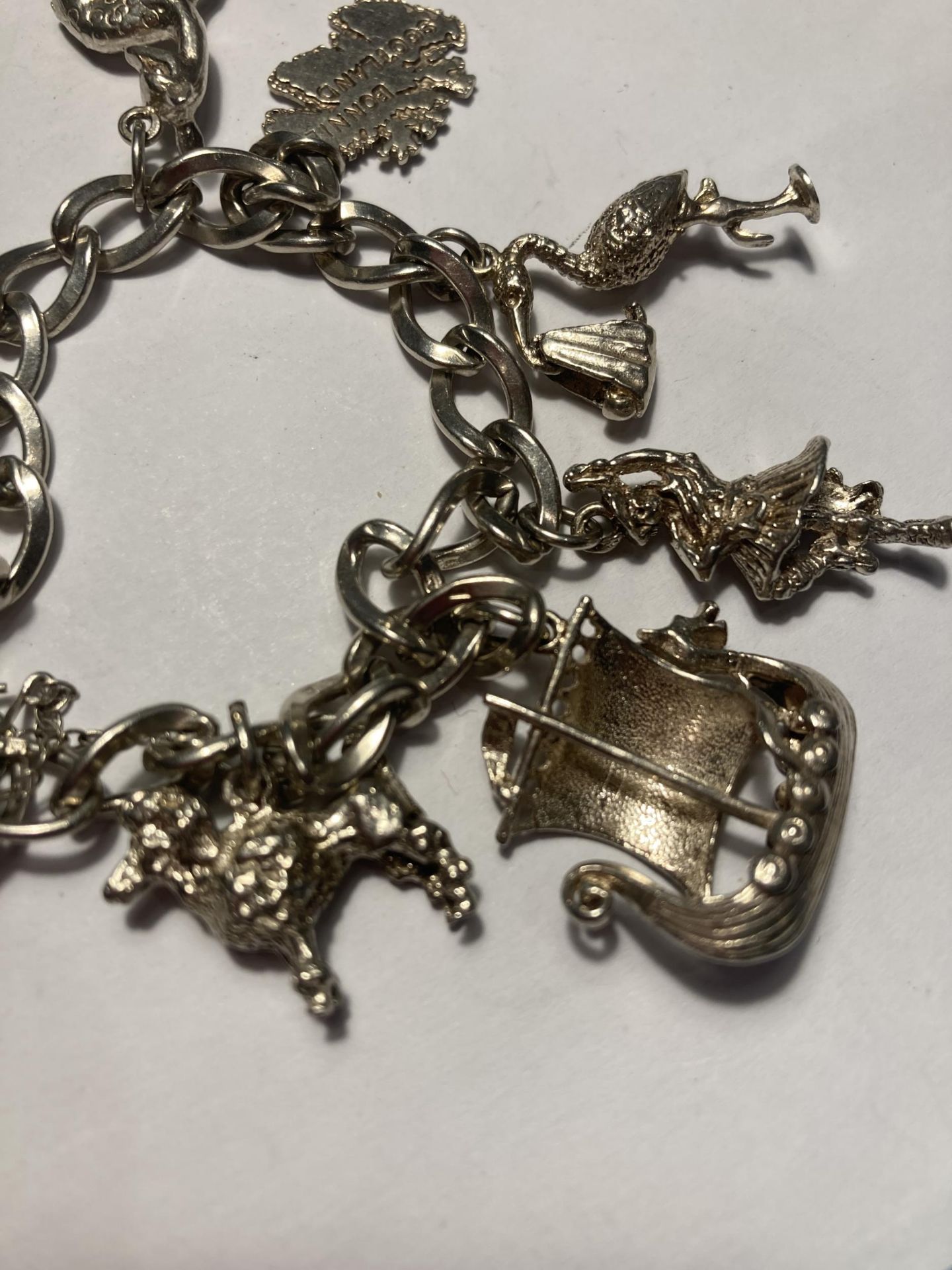 A SILVER CHARM BRACELET WITH EIGHT CHARMS AND A HEART PADLOCK - Bild 4 aus 4