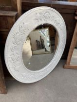 A 36" DIAMETER WALL MIRROR WITH BEVEL EDGE AND RAISED FOLIATE DECORATION