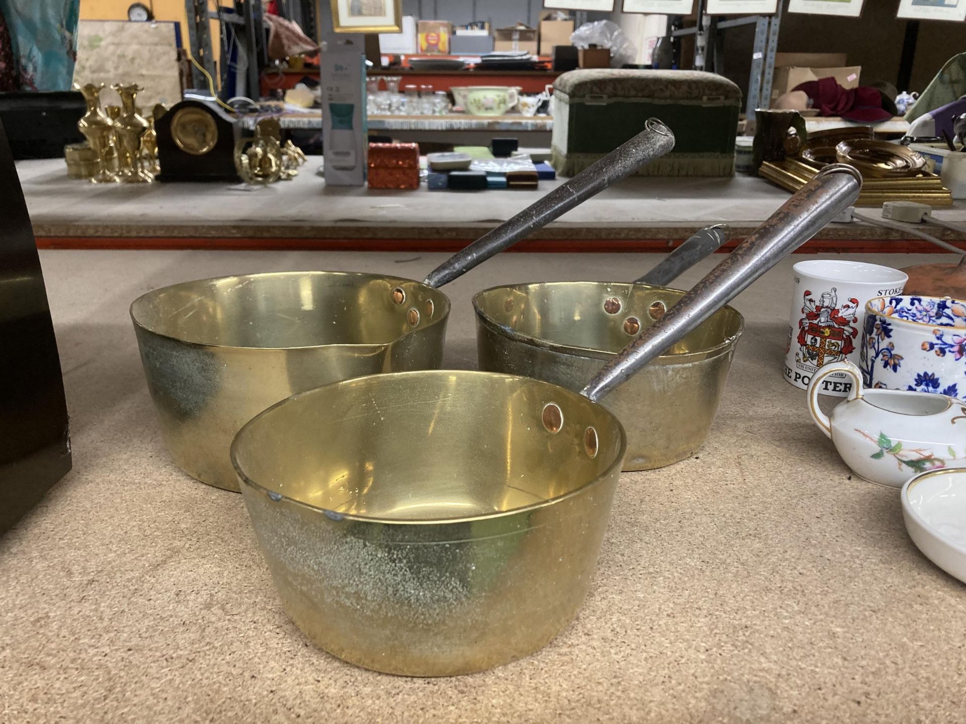 A GROUP OF THREE VINTAGE BRASS COOKING POTS WITH CAST HANDLES