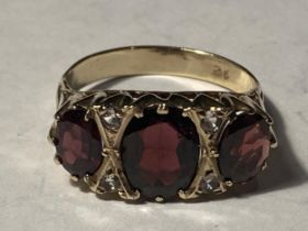 A 9 CARAT GOLD RING WITH THREE LARGE GARNETS SUUROUNDED BY CUBIC ZIRCONIAS SIZE R