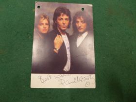 A PAUL MCCARTNEY SIGNED WINGS COLOURED POSTCARD