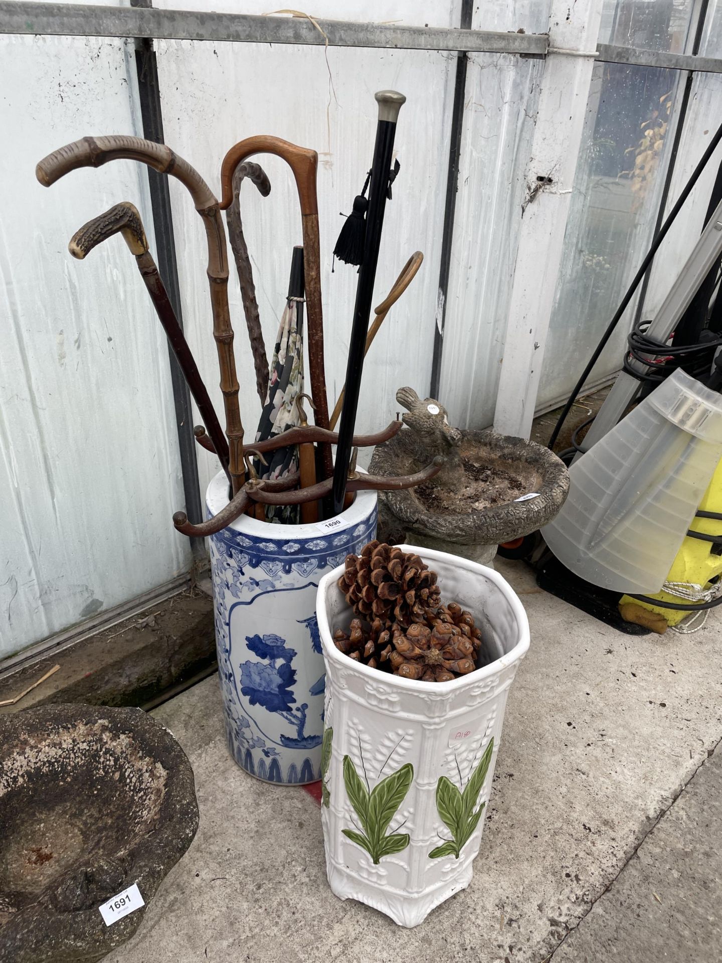 TWO CERAMIC STICK STANDS AND AN ASSORTMENT OF WALKING STICKS