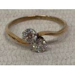 AN 18 CARAT YELLOW GOLD AND PLATINUM RING WITH TWO DIAMONDS APPROXIMATELY 0.25 CARATS EACH ON A