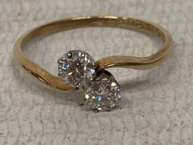 AN 18 CARAT YELLOW GOLD AND PLATINUM RING WITH TWO DIAMONDS APPROXIMATELY 0.25 CARATS EACH ON A