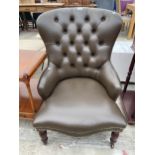 A VICTORIAN STYLE BUTTON BACK LOUNGE CHAIR ON TURNED FRONT LEGS