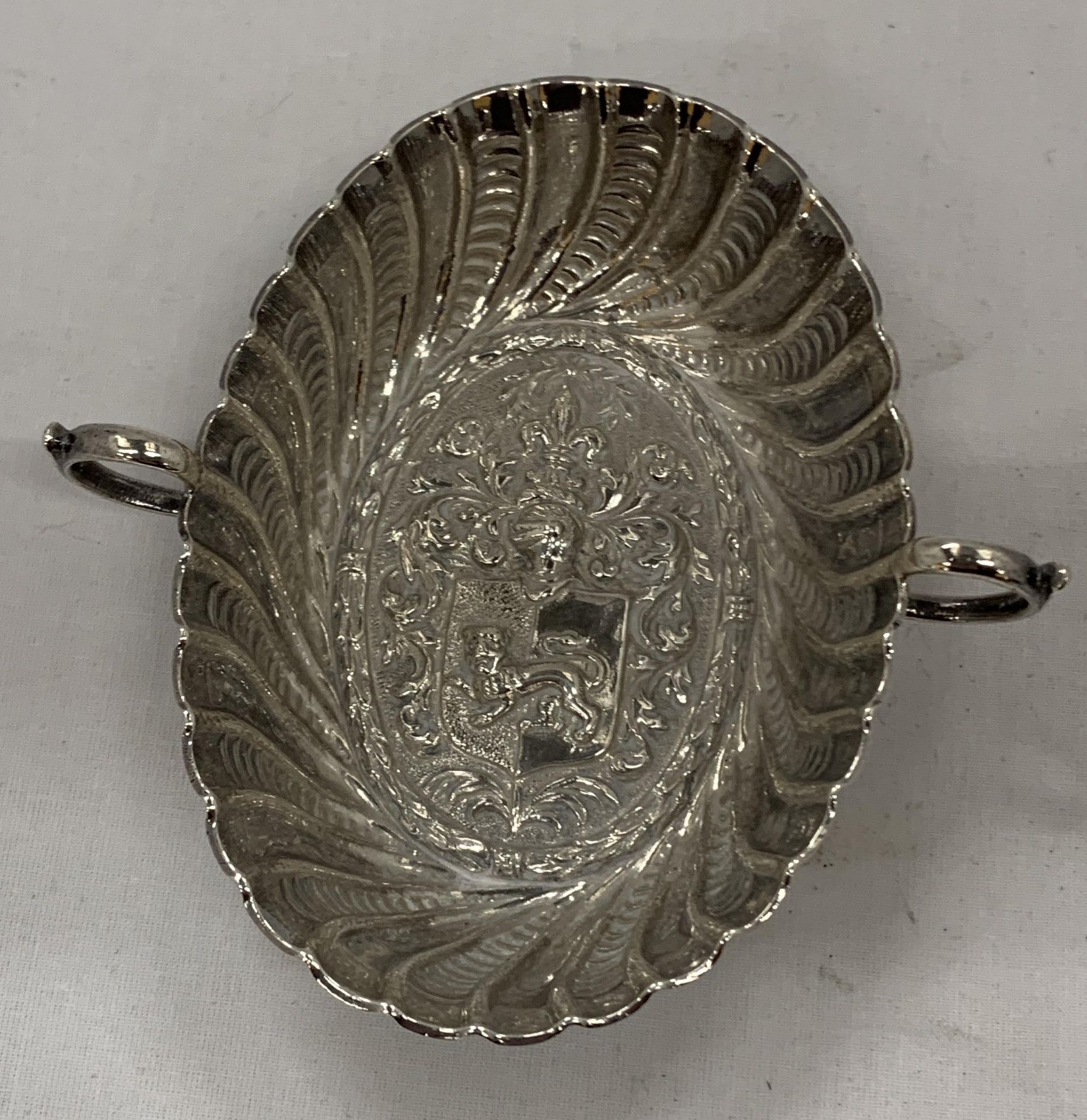 A TWIN HANDLED SILVER BOWL WITH COAT OF ARMS DESIGN