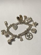A SILVER CHARM BRACELET WITH TEN CHARMS AND A HEART PADLOCK
