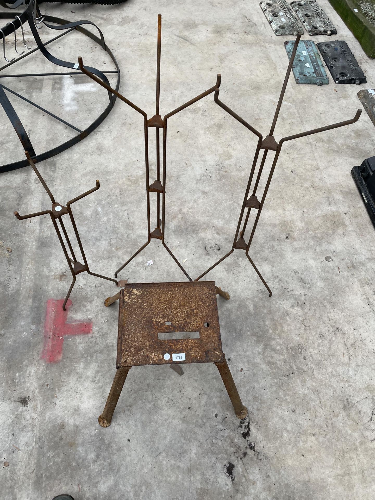 A METAL STOOL AND THREE METAL SHOP DISPLAY STANDS
