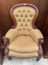 A VICTORIAN STYLE SPOON BACK LOUNGE CHAIR WITH BUTTON BACK ON TURNED AND FLUTED FRONT LEGS