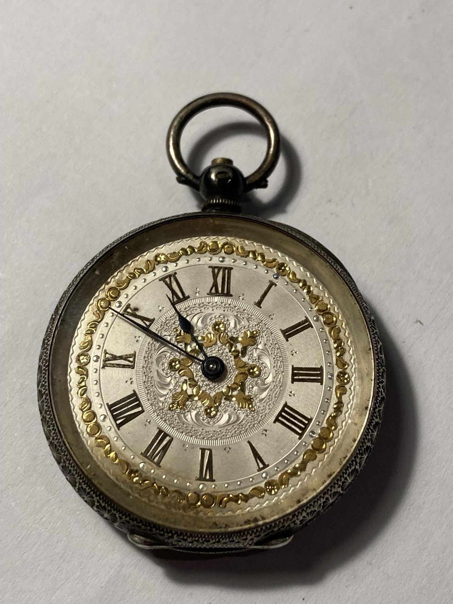 A LADIES SILVER FOB WATCH WITH DECORATIVE FACE
